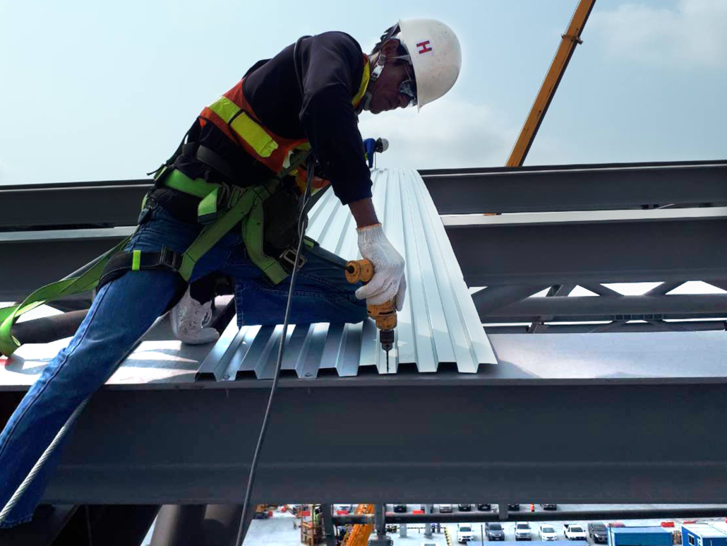 a construction worker drilling metal