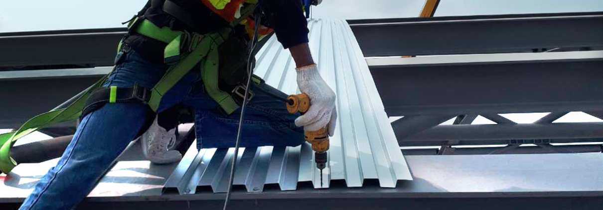construction worker drilling metal